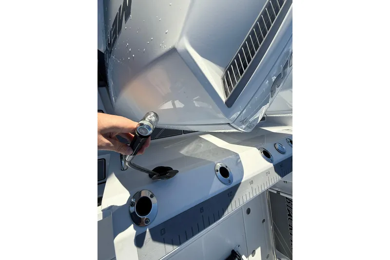 Slide: The Image of Hand holding a hose on a 2022 Blackfin 252 CC boat deck. - 5