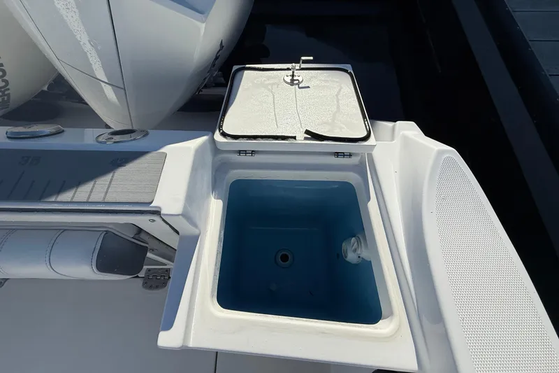 Slide: The Image of 2022 Blackfin 252 CC boat with open storage compartment and visible engine details. - 9