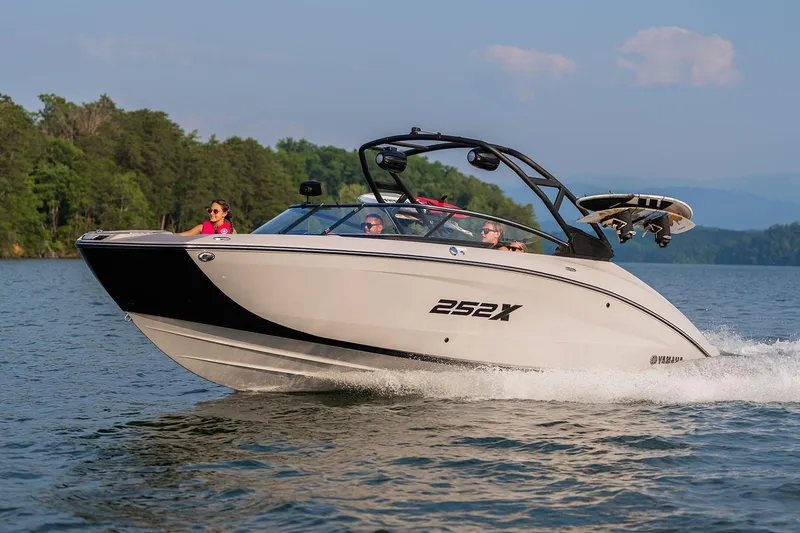 Slide: The Image of Manufacturer Provided Image: 2026 Yamaha Boats 252XE cruising on a scenic lake with passengers enjoying the ride. - 1