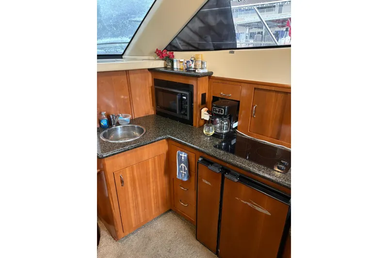 Slide: The Image of 2005 Carver 41 Cockpit Motor Yacht kitchen with sink, microwave, and coffee maker. - 17