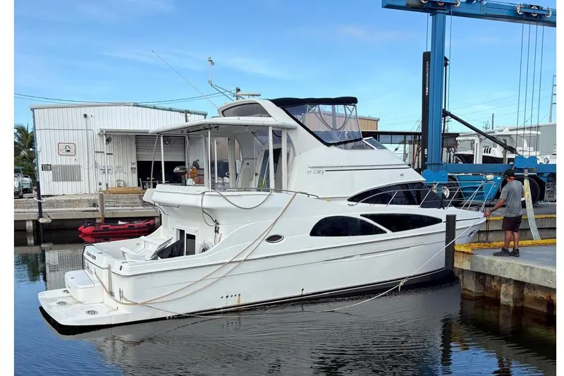 Slide: The Image of 2005 Carver 41 Cockpit Motor Yacht docked at marina with blue sky background. - 5