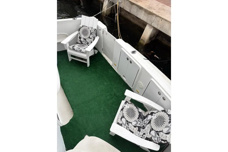 Slide: The Image of 2005 Carver 41 Cockpit Motor Yacht with green carpet and floral cushioned chairs. - 12