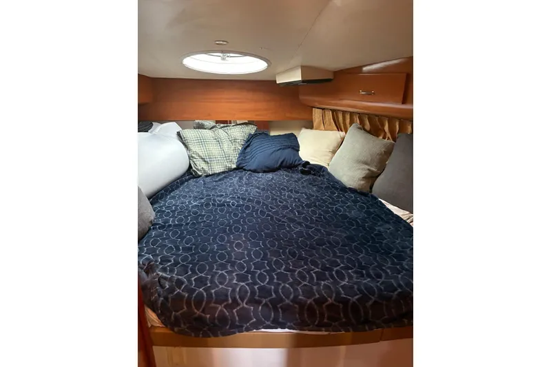 Slide: The Image of Cozy bedroom in 2005 Carver 41 Cockpit Motor Yacht with plush bedding and pillows. - 16