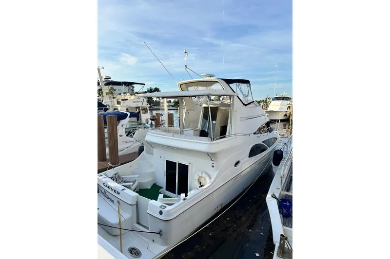 Slide: The Image of 2005 Carver 41 Cockpit Motor Yacht docked at marina, side view. - 2