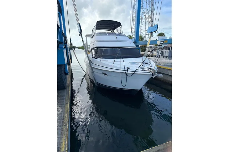 Slide: The Image of 2005 Carver 41 Cockpit Motor Yacht docked in a marina, front view. - 7