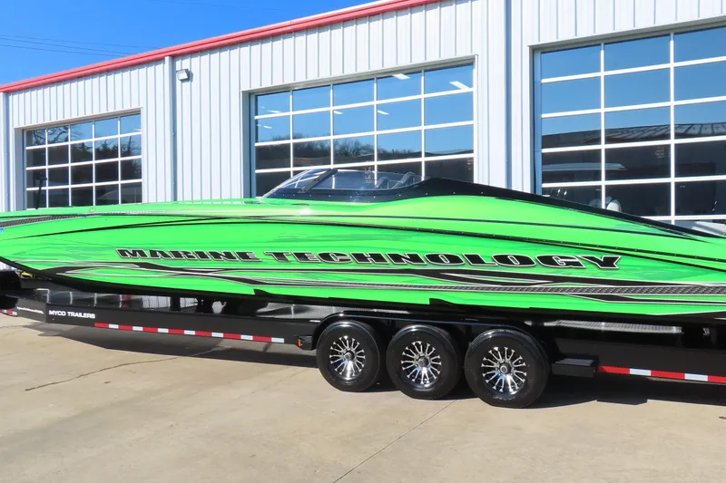 Slide: The Image of 2023 MTI 390X speedboat in vibrant green on a trailer outside a garage. - 11