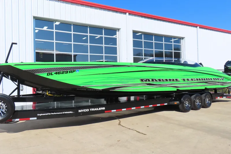 Slide: The Image of Bright green 2023 MTI 390X powerboat on trailer outside a garage. - 12