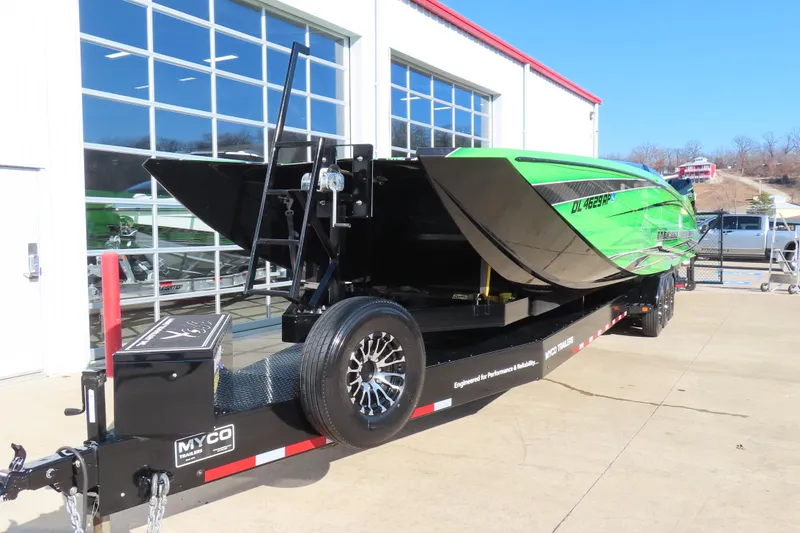 Slide: The Image of 2023 MTI 390X powerboat on trailer, vibrant green design, parked outside a garage. - 14