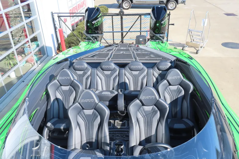 Slide: The Image of 2023 MTI 390X boat with sleek gray seating and vibrant green accents. - 19