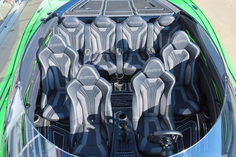 Slide: The Image of 2023 MTI 390X boat interior with sleek gray seats and green accents. - 37