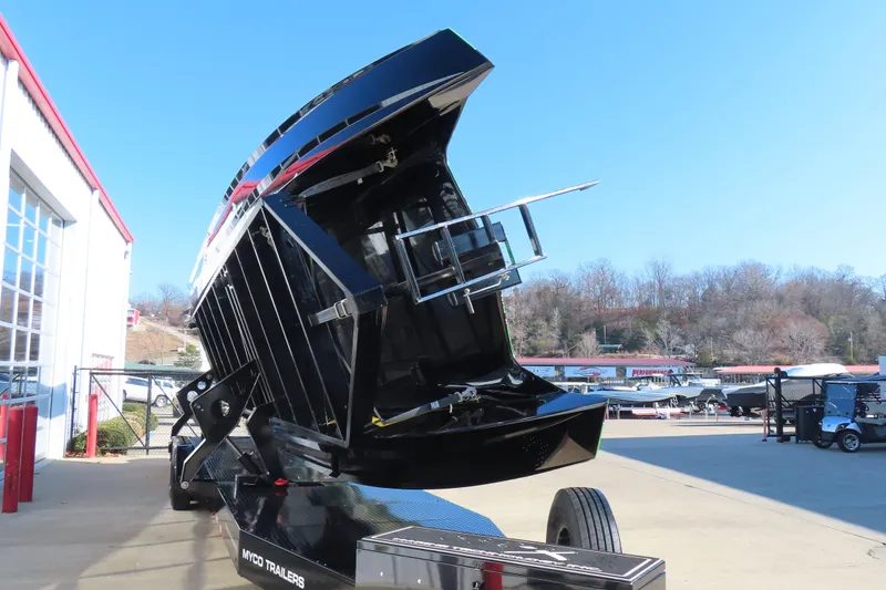 Slide: The Image of 2023 MTI 390X boat on trailer, tilted for display outside a showroom. - 5