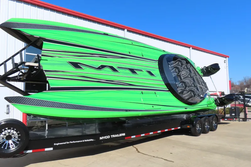 Slide: The Image of Green MTI 390X powerboat on trailer, 2023 model, parked outside a building. - 6