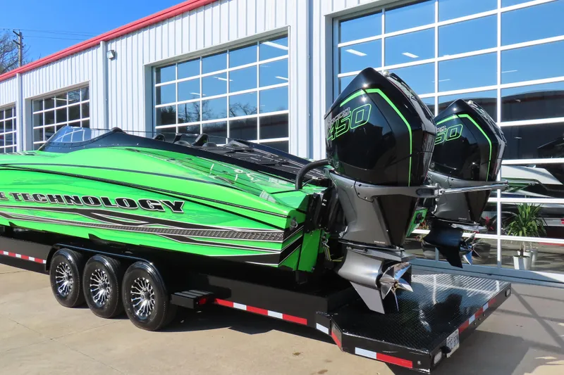 Slide: The Image of 2023 MTI 390X powerboat with dual engines on a trailer, vibrant green design. - 9