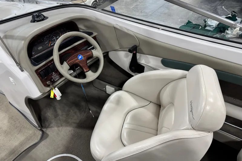 Slide: The Image of Interior of a 1999 Four Winns 220 Horizon SS boat, featuring steering wheel and captain's seat. - 11