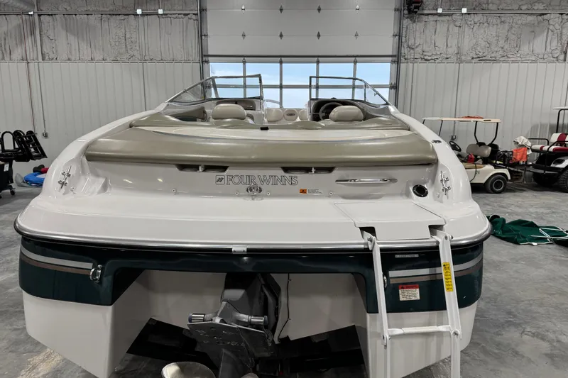 Slide: The Image of 1999 Four Winns 220 Horizon SS boat in a garage, rear view with ladder. - 6