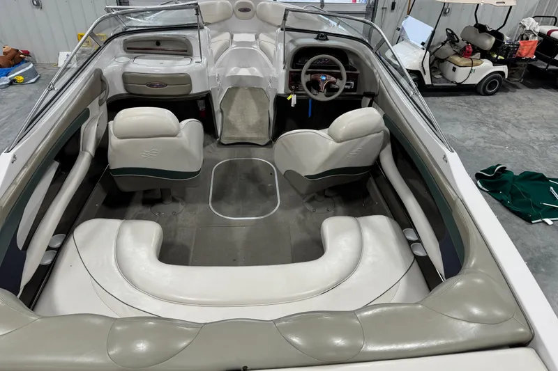 Slide: The Image of 1999 Four Winns 220 Horizon SS boat interior with white seating and steering wheel. - 8