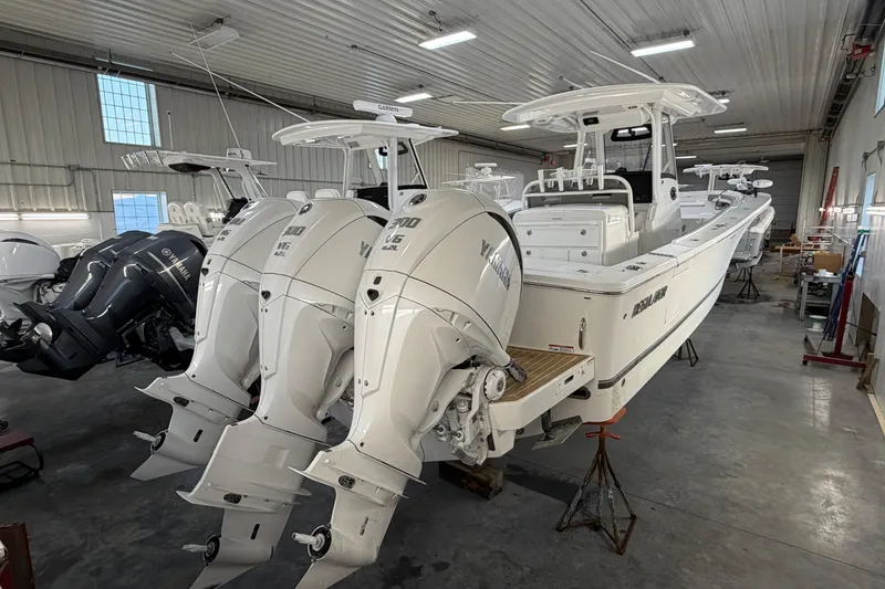 Slide: The Image of 2024 Regulator 34 boat with triple Yamaha engines in a storage facility. - 11