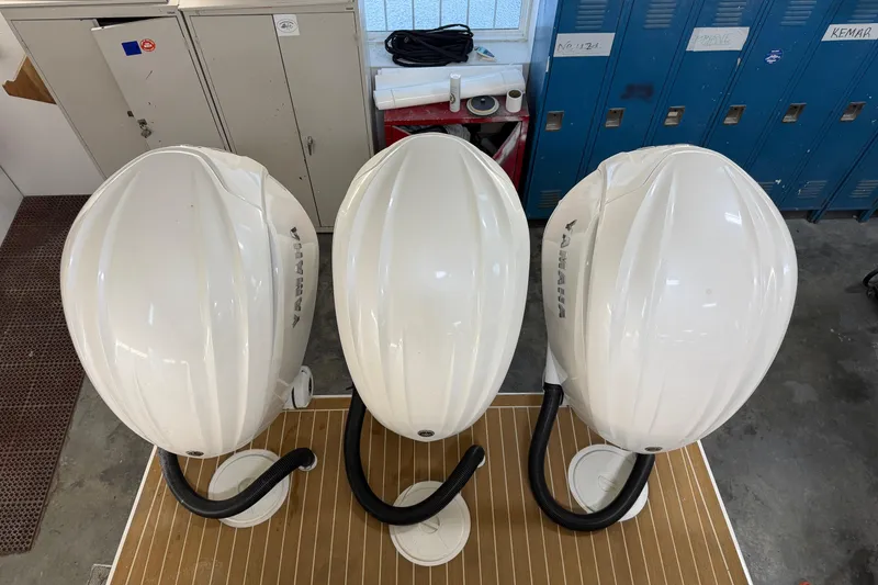 Slide: The Image of Three Yamaha outboard motor covers in a workshop, viewed from above. - 12