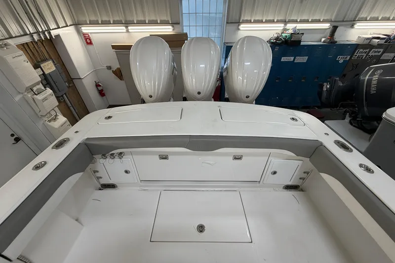 Slide: The Image of 2024 Regulator 34 boat interior with triple outboard engines in a garage setting. - 13