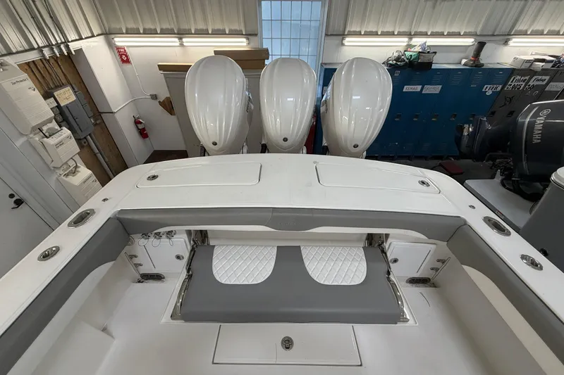 Slide: The Image of 2024 Regulator 34 boat with triple outboard engines in a workshop setting. - 14