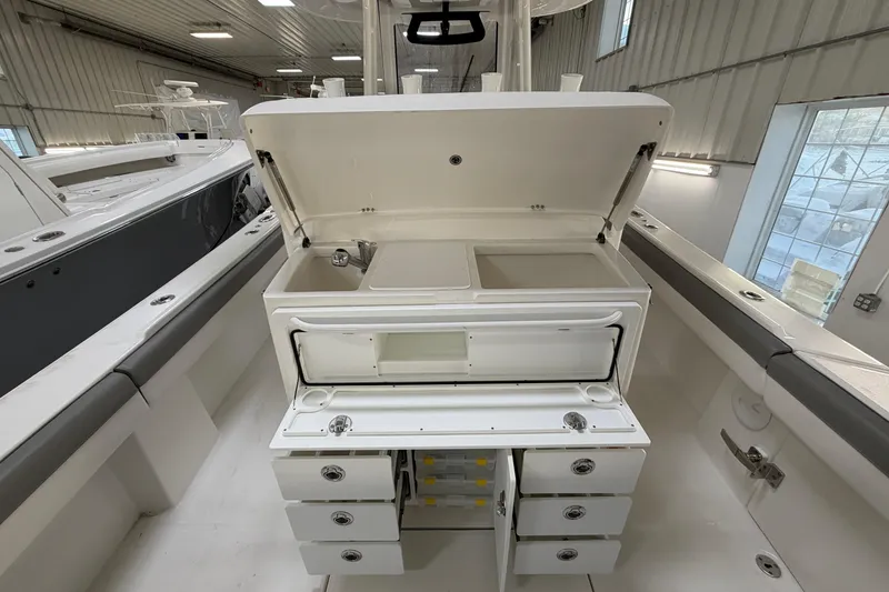 Slide: The Image of 2024 Regulator 34 boat interior with open storage compartments and sink. - 17