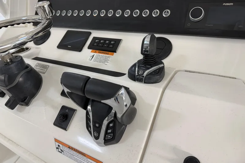 Slide: The Image of 2024 Regulator 34 boat control panel with steering wheel and throttle levers. - 24