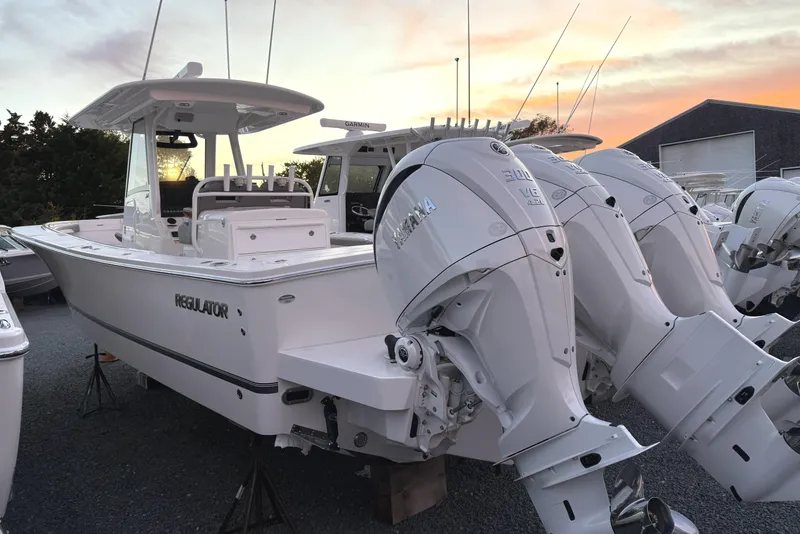 Slide: The Image of 2024 Regulator 34 boat with triple outboard engines at sunset. - 3