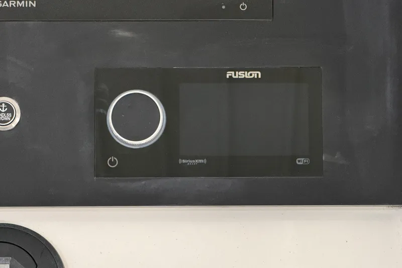 Slide: The Image of 2024 Regulator 34 boat dashboard featuring Fusion audio system and Garmin controls. - 30