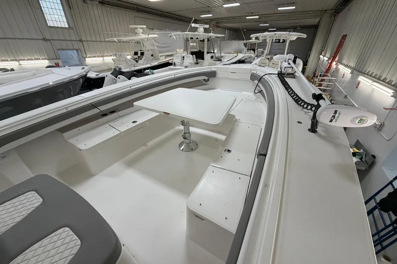 Slide: The Image of 2024 Regulator 34 boat interior with seating and table in a showroom. - 38