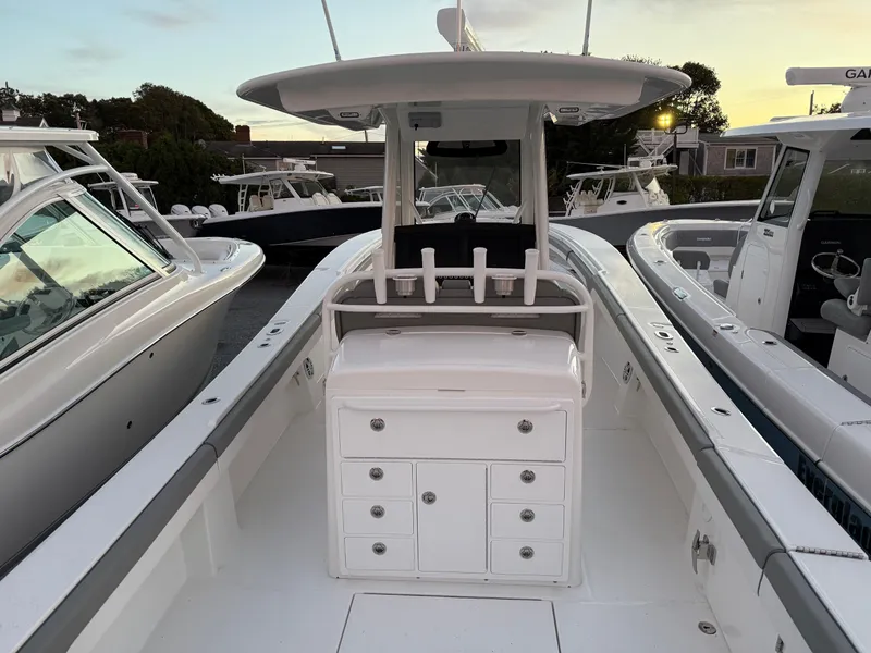 Slide: The Image of 2024 Regulator 34 boat interior with storage compartments and seating, docked at sunset. - 4