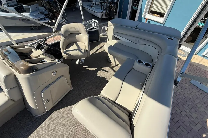 Slide: The Image of 2019 Bennington 188 SLV pontoon boat interior with beige seating and helm. - 22