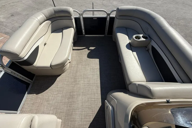 Slide: The Image of 2019 Bennington 188 SLV pontoon boat interior with beige seating and cup holders. - 23