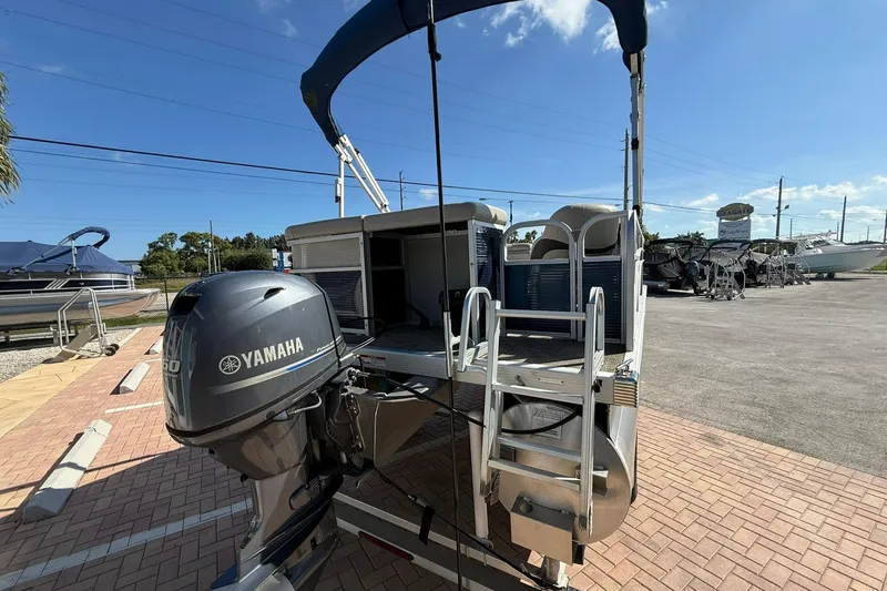 Slide: The Image of 2019 Bennington 188 SLV pontoon boat with Yamaha outboard motor, parked on brick pavement. - 8