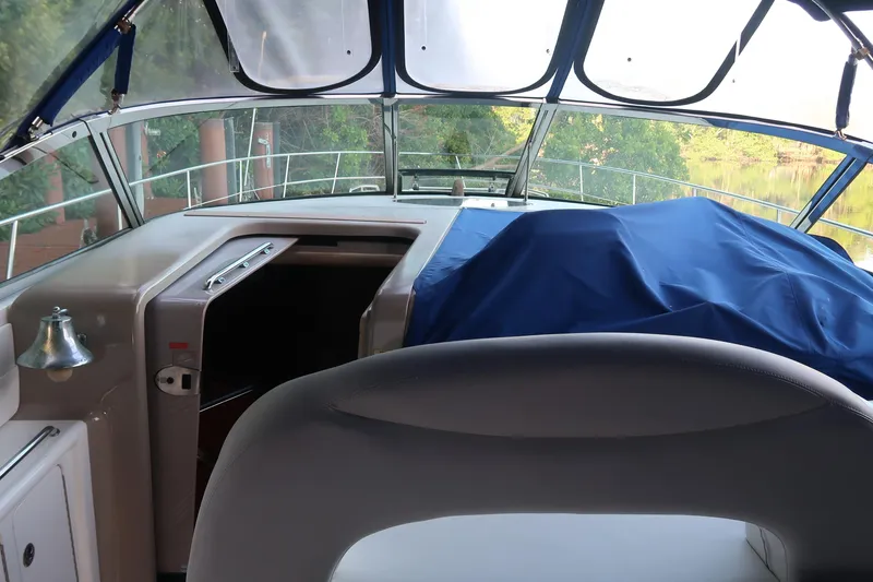 Slide: The Image of 2002 Sea Ray 410 Sundancer cockpit with covered dashboard and scenic view. - 20