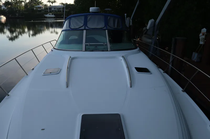 Slide: The Image of 2002 Sea Ray 410 Sundancer yacht docked by calm waters, front deck view. - 22