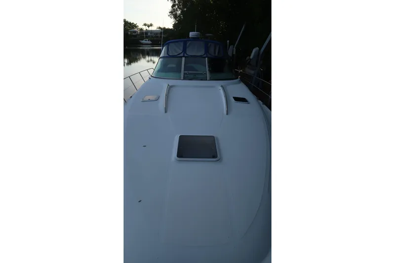 Slide: The Image of 2002 Sea Ray 410 Sundancer yacht, front deck view, docked by calm waters. - 23