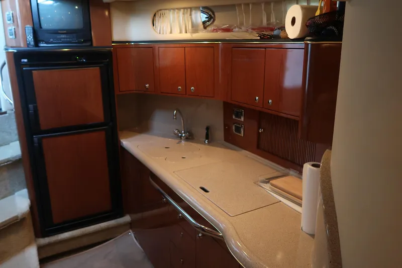 Slide: The Image of Luxurious 2002 Sea Ray 410 Sundancer yacht kitchen with wood cabinets and modern appliances. - 30