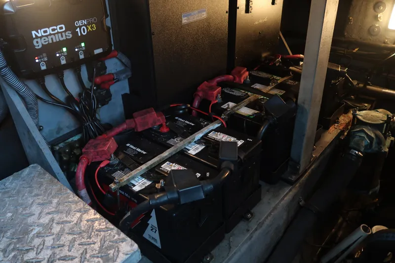 Slide: The Image of Engine room of 2002 Sea Ray 410 Sundancer with batteries and Noco Genius charger. - 44