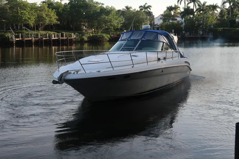 Slide: The Image of 2002 Sea Ray 410 Sundancer yacht cruising on a serene waterway. - 9