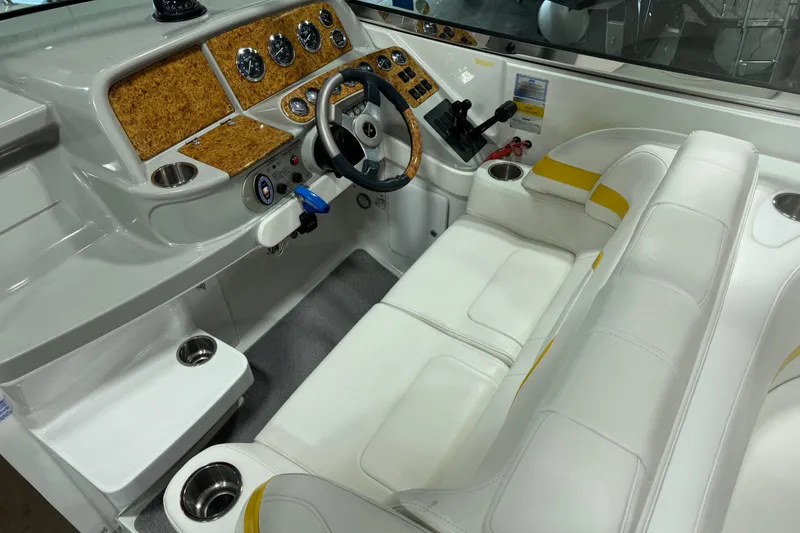 Slide: The Image of 2005 Formula 330 Sun Sport boat interior with white seating and wood-accented dashboard. - 8