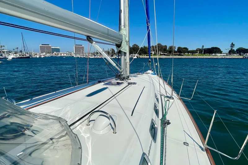 Slide: The Image of 2003 Beneteau First 47.7 sailboat on calm waters, clear sky, marina in background. - 10