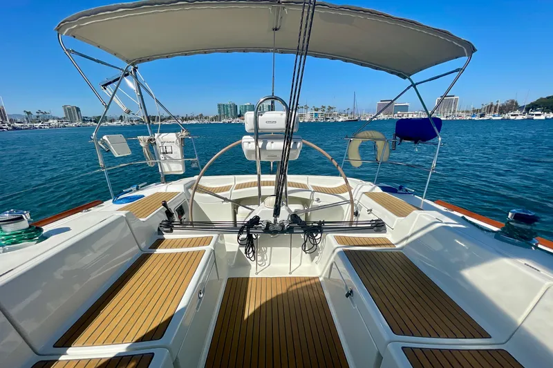 Slide: The Image of Beneteau First 47.7 sailboat cockpit, 2003 model, with teak decking and marina view. - 13