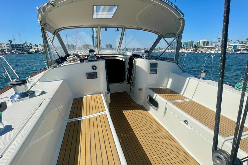 Slide: The Image of Beneteau First 47.7 sailboat cockpit, 2003 model, with teak flooring and marina view. - 21