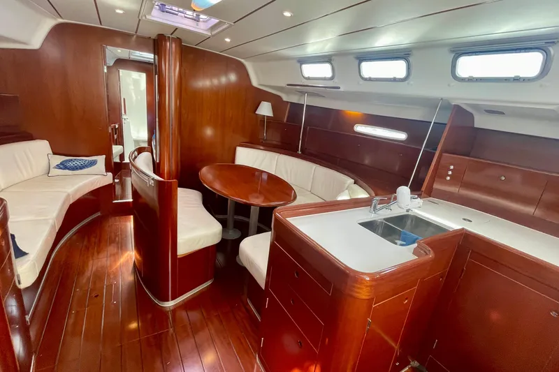 Slide: The Image of Luxurious interior of 2003 Beneteau First 47.7 yacht with wood finish and white seating. - 25