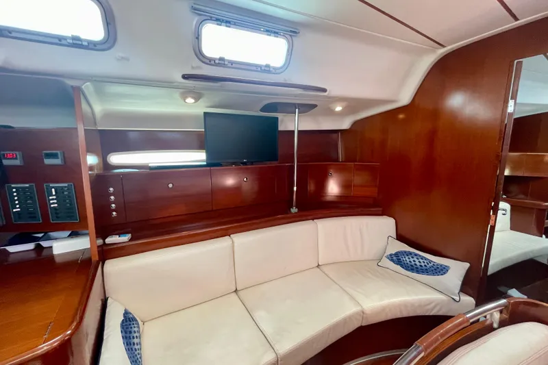 Slide: The Image of Interior of 2003 Beneteau First 47.7 yacht with wood finish and white seating. - 28