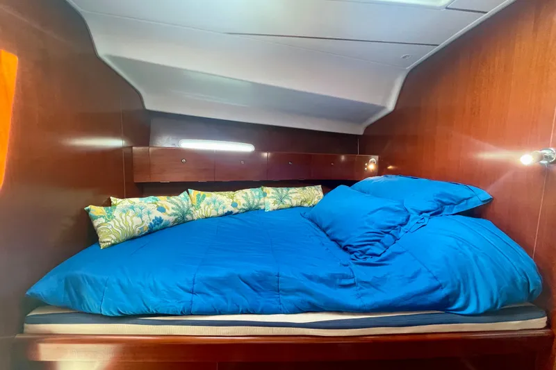 Slide: The Image of Cozy cabin interior of 2003 Beneteau First 47.7 with blue bedding and wooden finish. - 50
