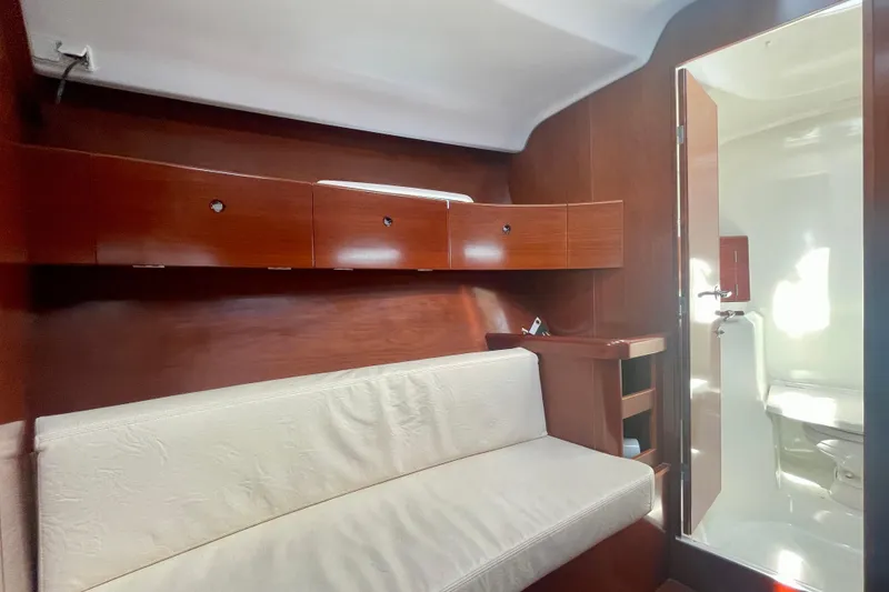 Slide: The Image of Interior of 2003 Beneteau First 47.7 yacht with wooden cabinets and white seating. - 52