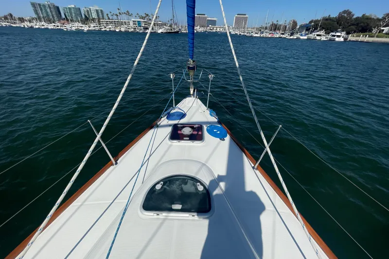 Slide: The Image of 2003 Beneteau First 47.7 sailboat on water, marina and buildings in background. - 6