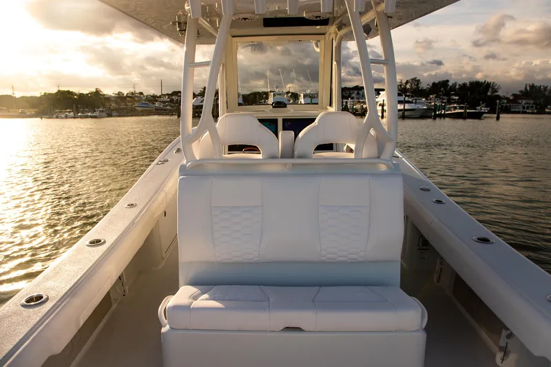 Slide: The Image of 2026 Yellowfin 36 Offshore boat interior with white seating, docked at sunset. - 10