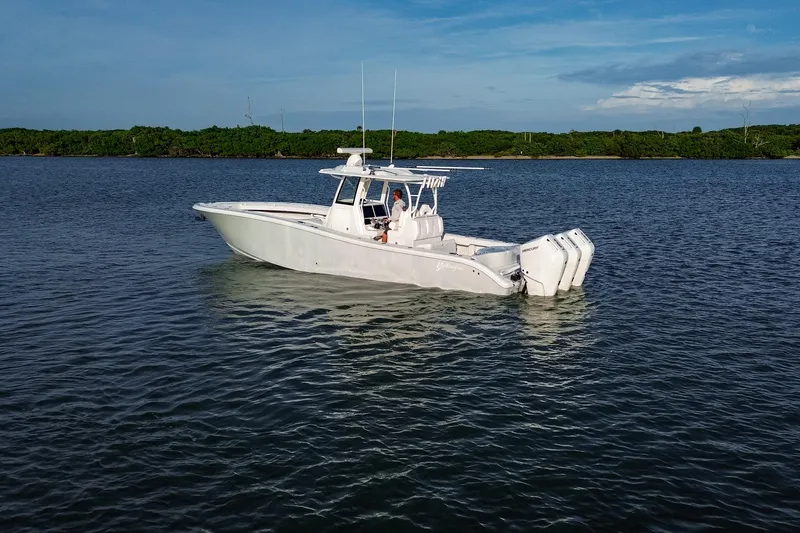 Slide: The Image of 2026 Yellowfin 36 Offshore boat on calm water with triple outboard engines. - 101